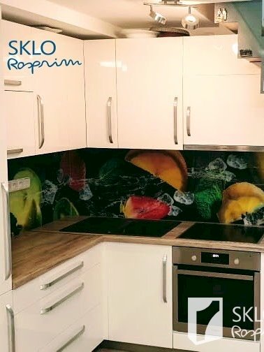 Barevná skleněná deska s obrázkem ovoce umístěná za kuchyňskou linkou