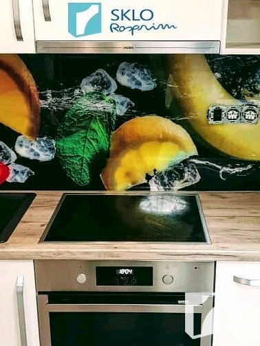Barevná skleněná deska s obrázkem ovoce umístěná za kuchyňskou linkou
