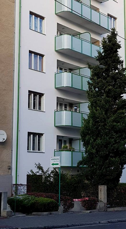 Skleněné balkony bytového domu z ohýbaného skla