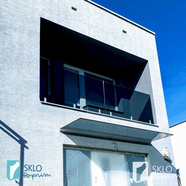 Skleněné zábradlí balkónu a skleněná stříška nad vchodovými dveřmi